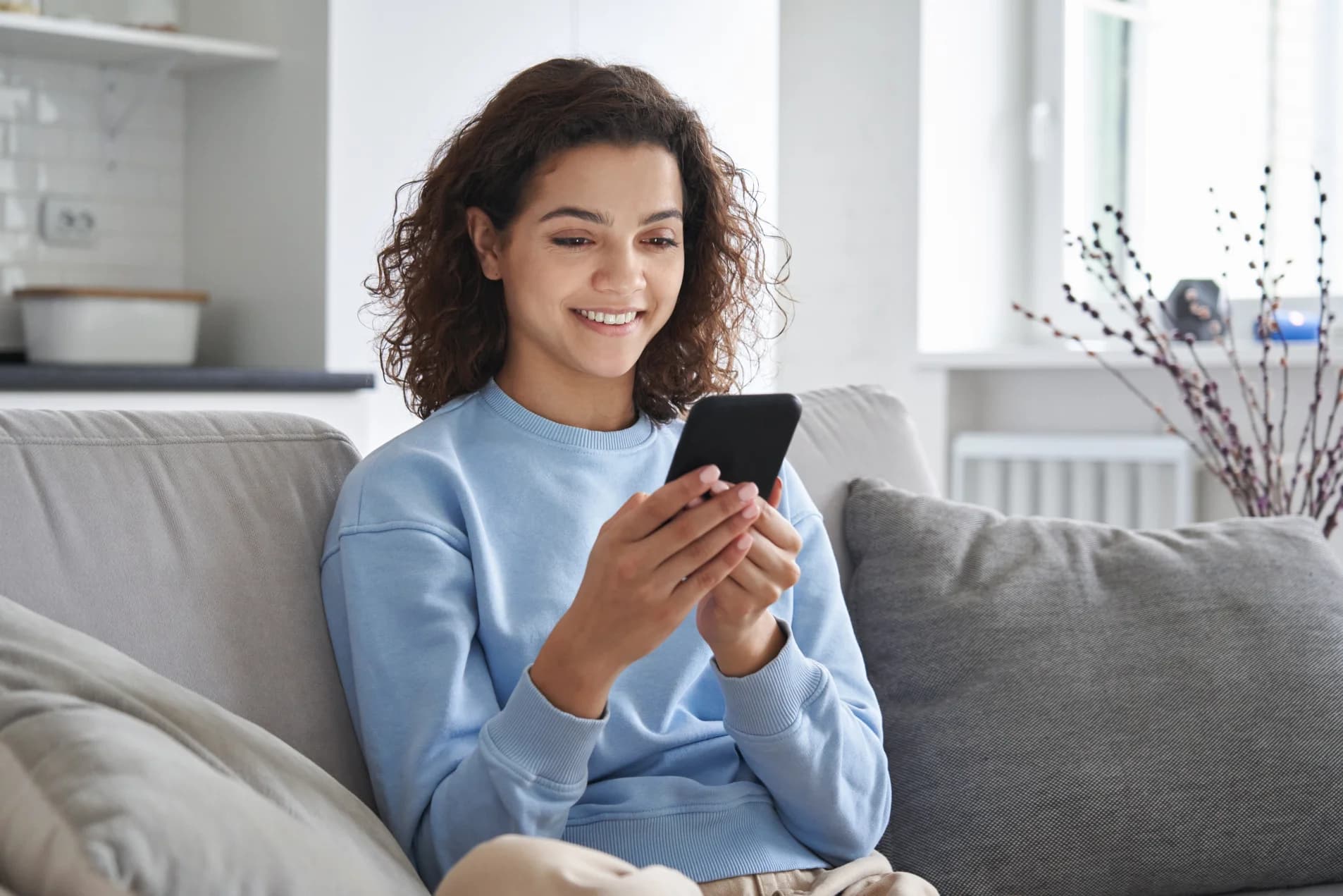 Smiling young woman using smartphone