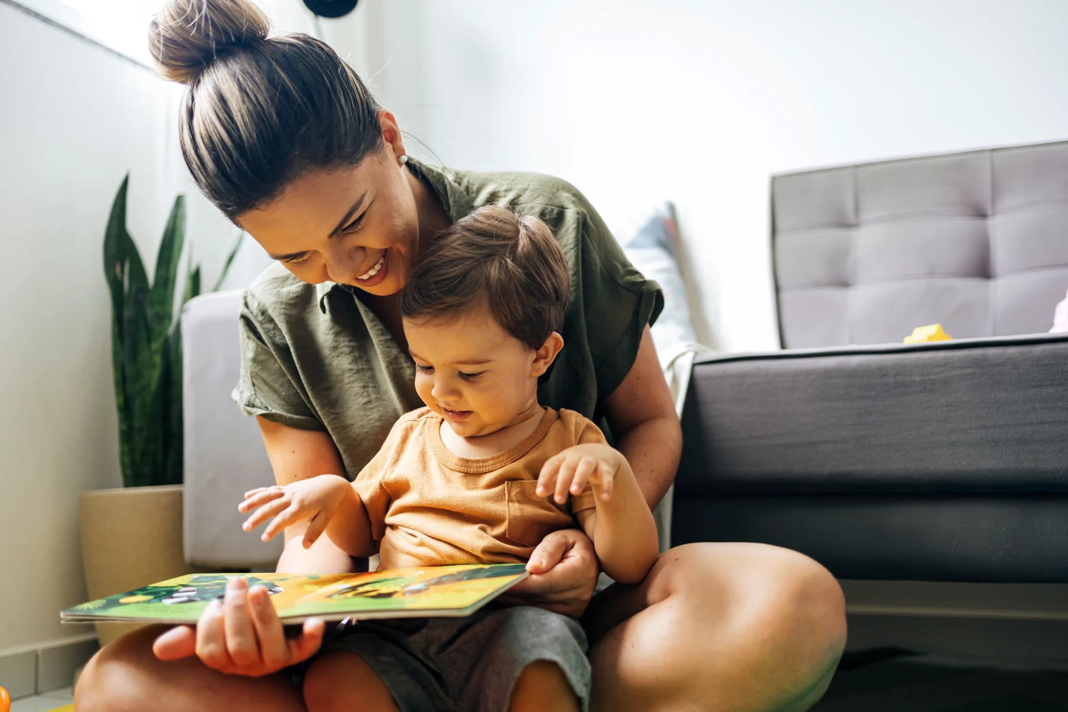 Mom reading a book with baby boy at home
