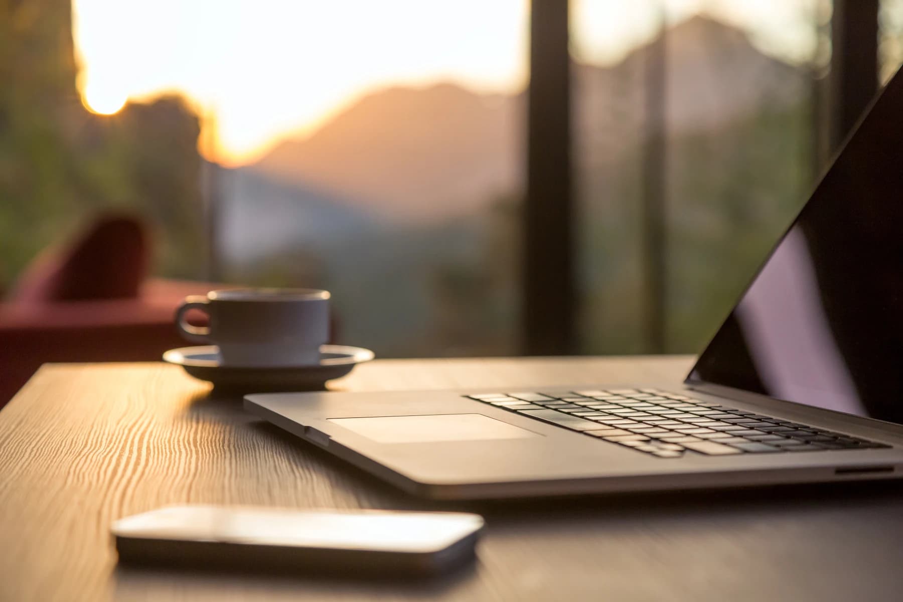 Laptop and phone on a table, representing a remote work side hustle setup Laptop and phone on a table, representing a remote work side hustle setup